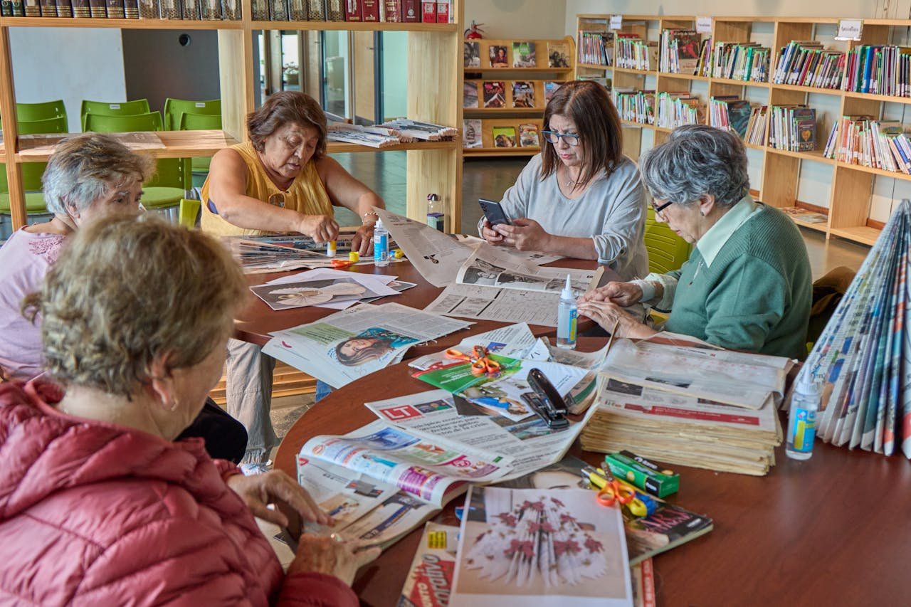 A group of senior adults participate in crafting activities in a library setting, fostering creativity and community.